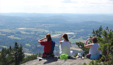 3 damer sitter på toppen av Skrehelle og nyter utsikten