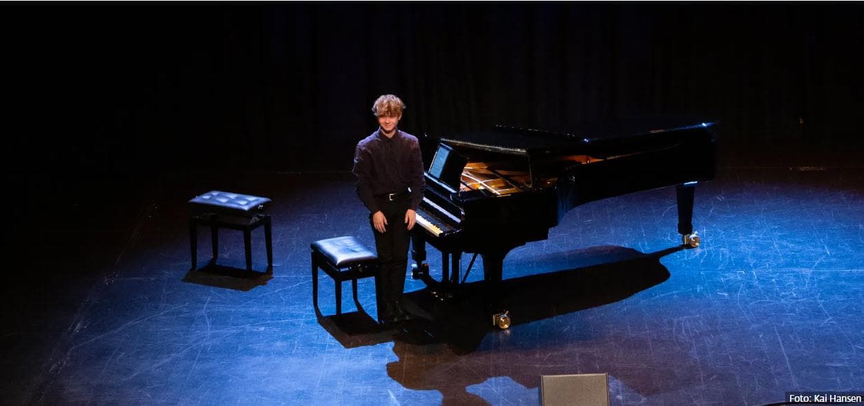 ung mann ved siden av en piano