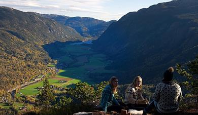 Tre turkledde jenter på toppen av Bindingsnuten i Flatdal.