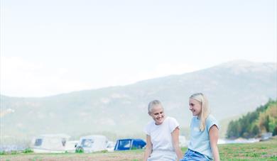 jenter sitter på en stein ved Telnessanden strand