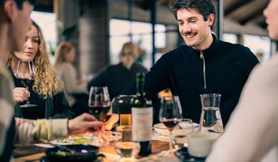 gjester som koser seg med mat og vin på restaurant Blikk Raw & Grill på Gaustablikk fjellresort