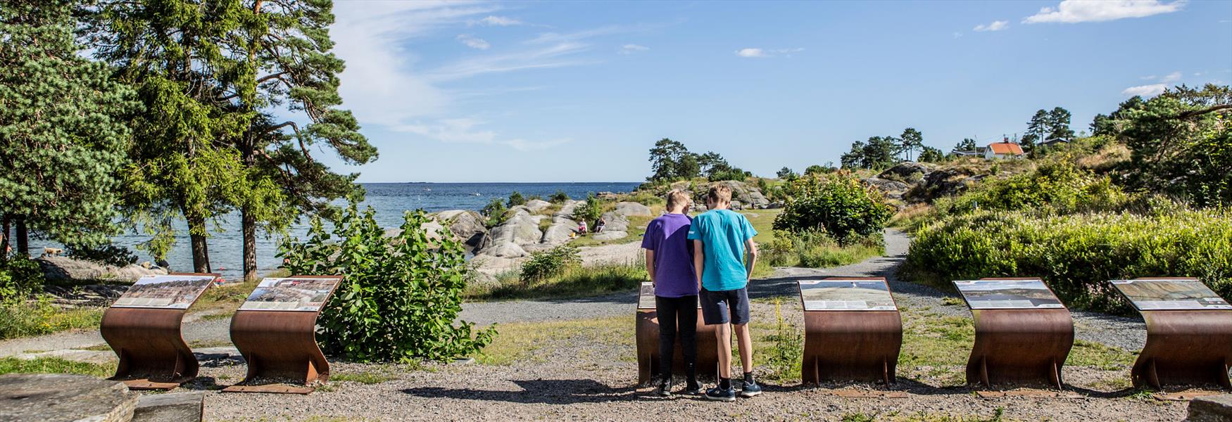 2 gutter ser på tavlene fra Geoparken ved Rognstranda