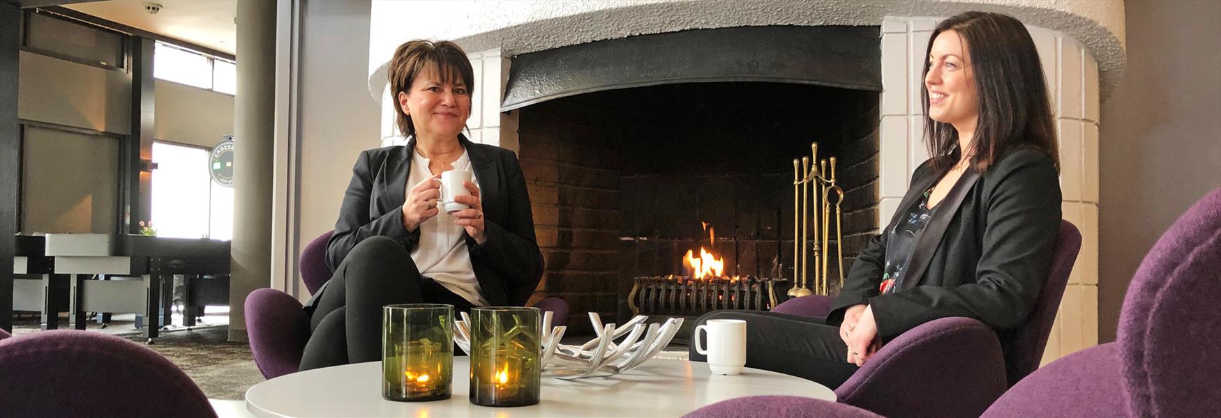2 damer sitter rundt et bord i lobbyen til Vic Hotell i Porsgrunn