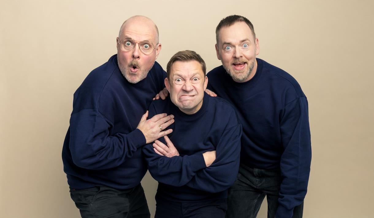 3 menn i blå genser og bukse