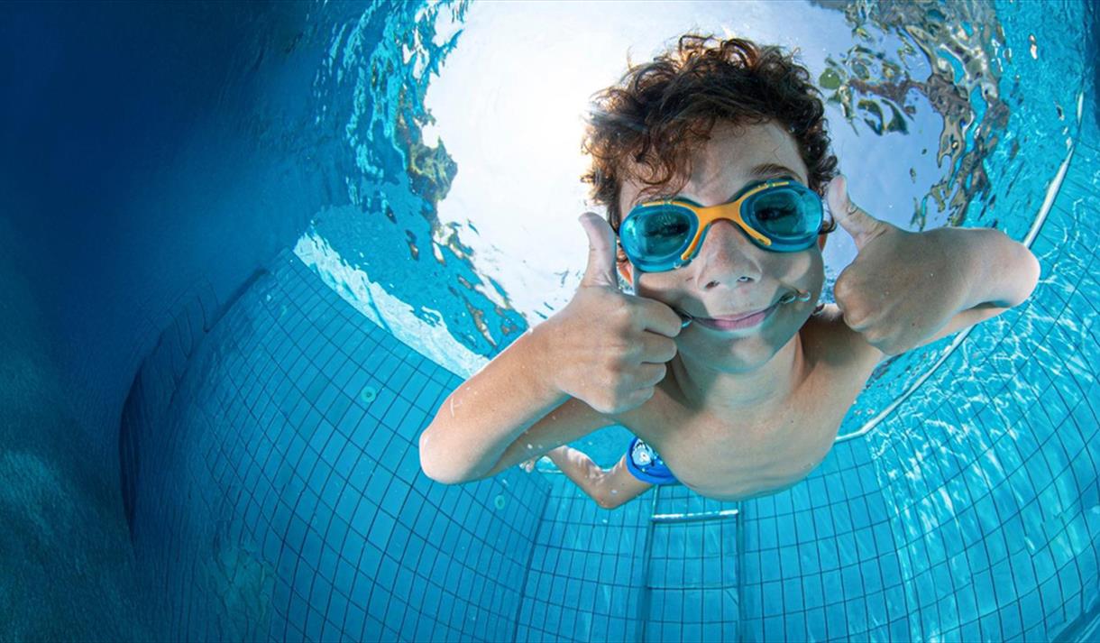 gutt som dykker i basseng på Skien fritidspark