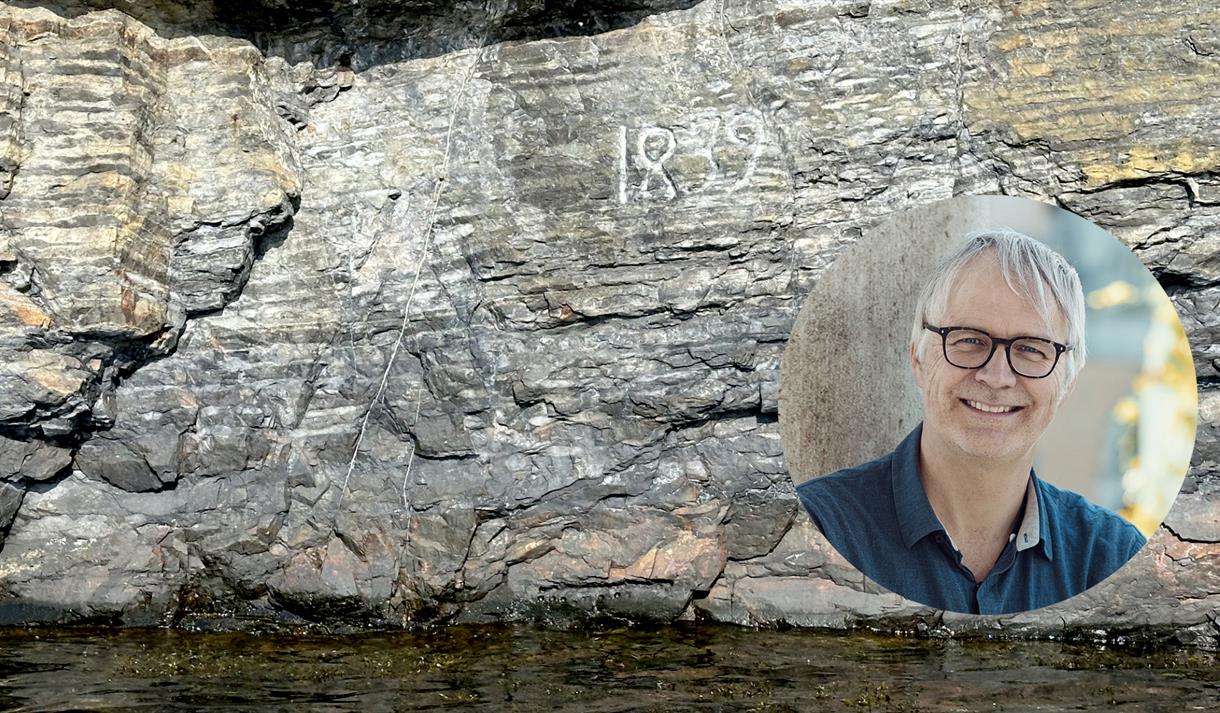 fjellformasjoner i bakgrunn med vann og ovalt bilde av mann med lyst hår og sorte briller