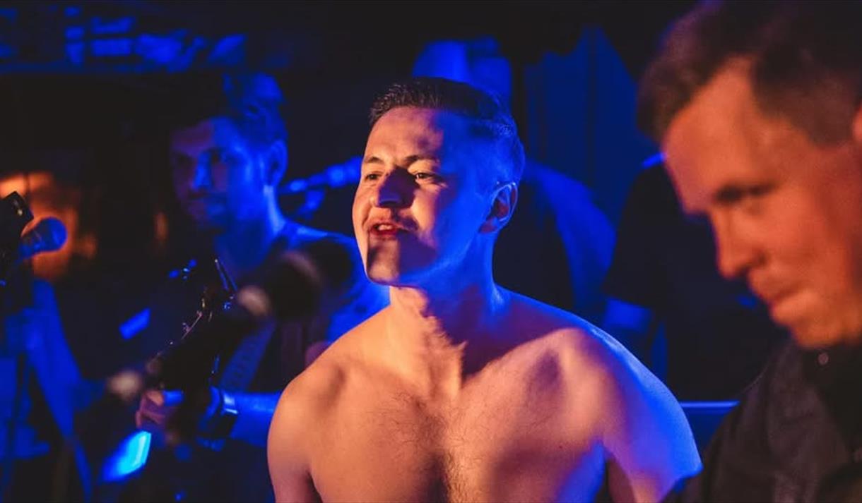 gutt i bar overkropp i blå farger som synger