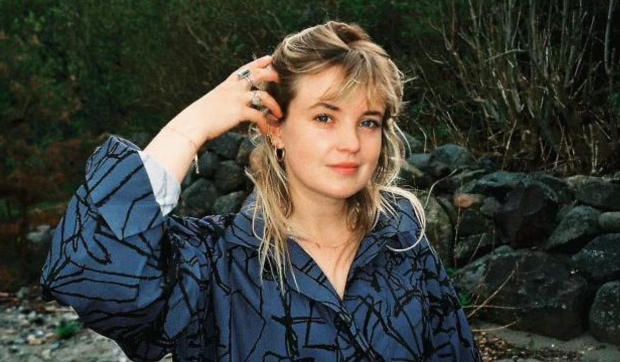 lys dame med blå og sortmønstret jakke