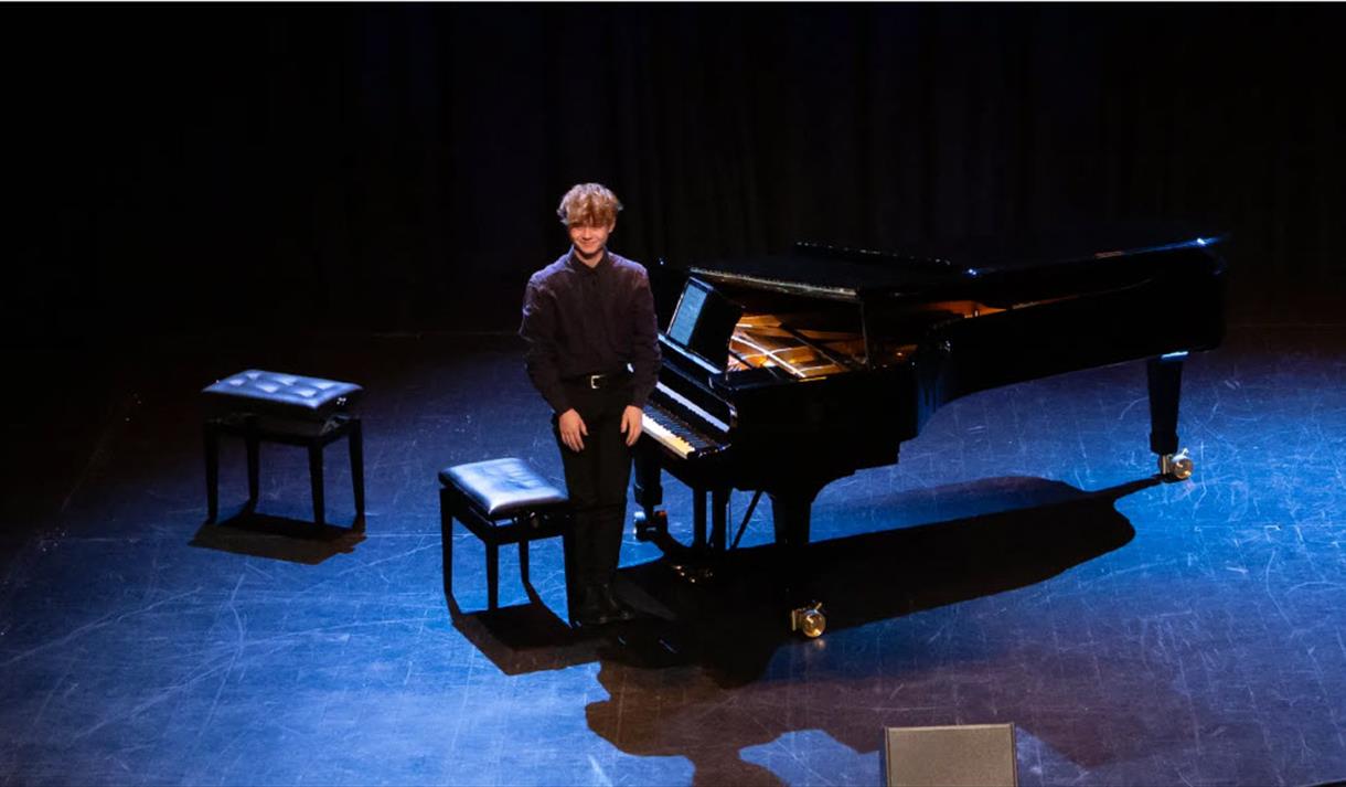 ung mann ved siden av en piano