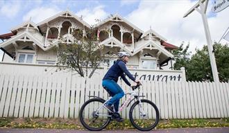 syklist sykler forbi et hus i Seljord