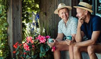 2 menn som sitter i hagen