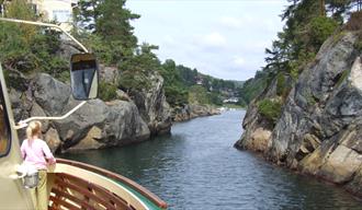 liten jente står på MS Dikkon og ser på vannet under skjærgårdsturen med MS Dikkon