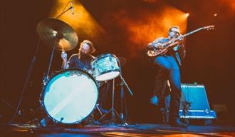 James McKinley på scenen med gitar og en mann på trommer