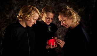 Peer Gynt Escape Room Skien. 3 personer som studerer Peers hjerte.