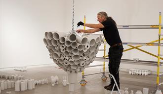 Kunsthall Grenland En mann monterer en utstilling