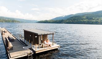 par sitter på en bank på den flytende badstue Dugg Sauna i Notodden