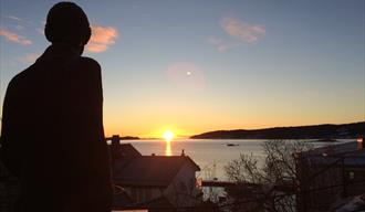 Edvard Munch Statue i Kragerø, med soloppgang i bakgrunnen