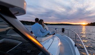 par sitter på dekk og nyter solnedgangen