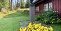 Byste og blomar ved inngangen til Skinnarlandsamlinga i Rauland.