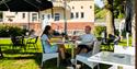 par sitter i hagen til Stasjonen kafé