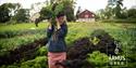 jente bak en bunt grønnsaker i åkeren på århus gård