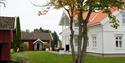 Hvitt gårdshus og rødt bryggerhus