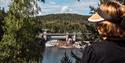 En dame som sitter på en benk på Skotfosstien og ser utover vannet