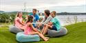 familie sitter på sitteputer på uteplassen til Quality Hotel Skjærgården