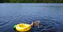 Jente som bader i Tinnemyra med gul badering i Notodden. Foto