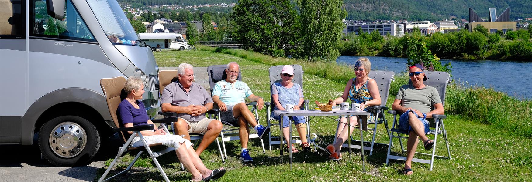 gruppe pensjonister som sitter foran en bobil