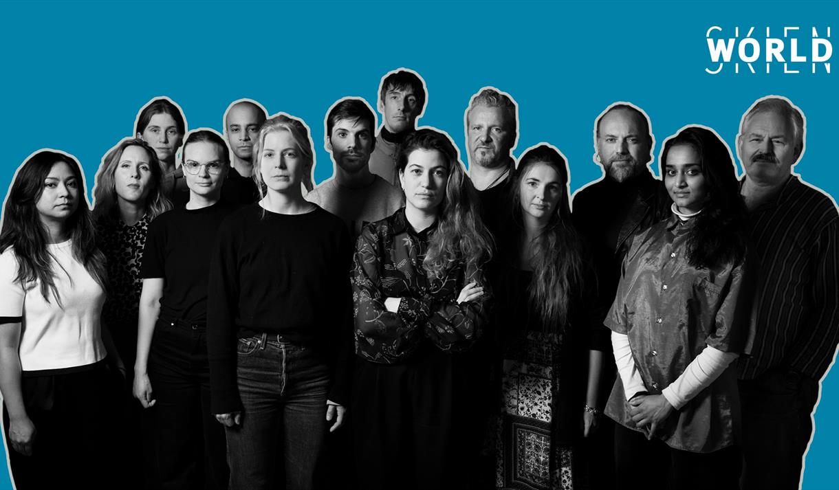 gruppe av menn og kvinner foran en blå bakgrunn