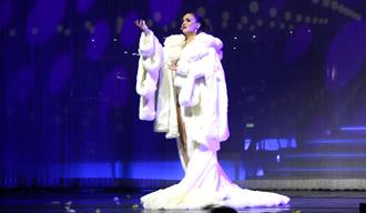 Hva skjer i Skien - Andrew Lloyd Webber Concert Gala. En dame i hvit lang kjole og hvit pels som synger på en scene
