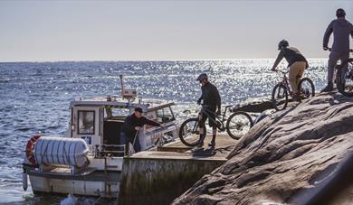 3 cyclists load their bikes on Kragerø Taxi Boat