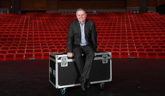 Ibsenhusets direktør Erik Rastad sitter på en koffert foran et auditorium