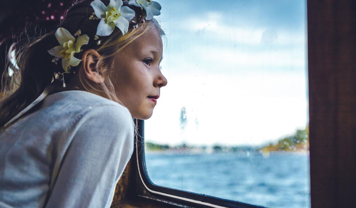 jente ser ut av vinduet på båten