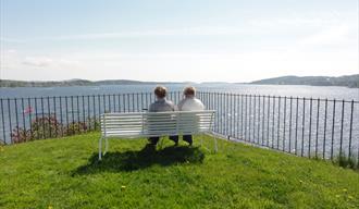 2 damer sitter på en benk på batteriet på øya i Brevik