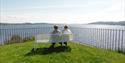 2 damer sitter på en benk på batteriet på øya i Brevik