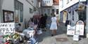 dame som seller varene sine på en trang gate i Brevik