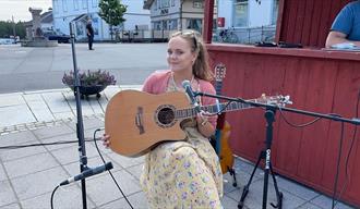 Gatemusikanter, en jente med gitar i Langesund sentrum