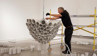 Kunsthall Grenland En mann monterer en utstilling