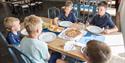 5 barn  rundt bord på innendørs spiseområde