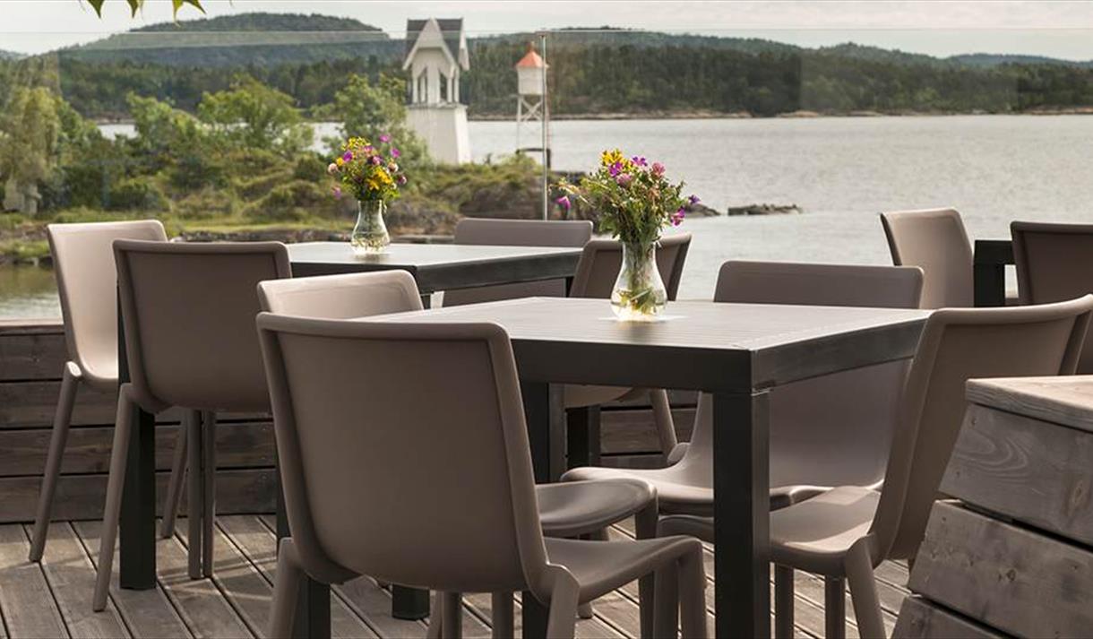 terrasse med bord og stoler samt utsikt mot vannet på Quality Hotel Skjærdården i Langesund