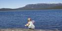 Jente med hov som sitter ved vannet på Follsjøen, Notodden. Foto