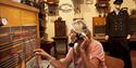dame som sitter i en gammel telefonsentrale som utstilles på Z-museum i Nissedal