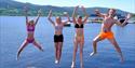 4 ungdom hopper fra bryggekanten ved Bystranda og Nesøya Marina, i Notodden. Foto