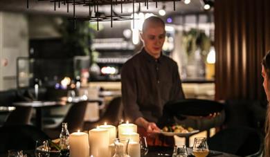servitør som serverer mat på restaurant Hovdestaul