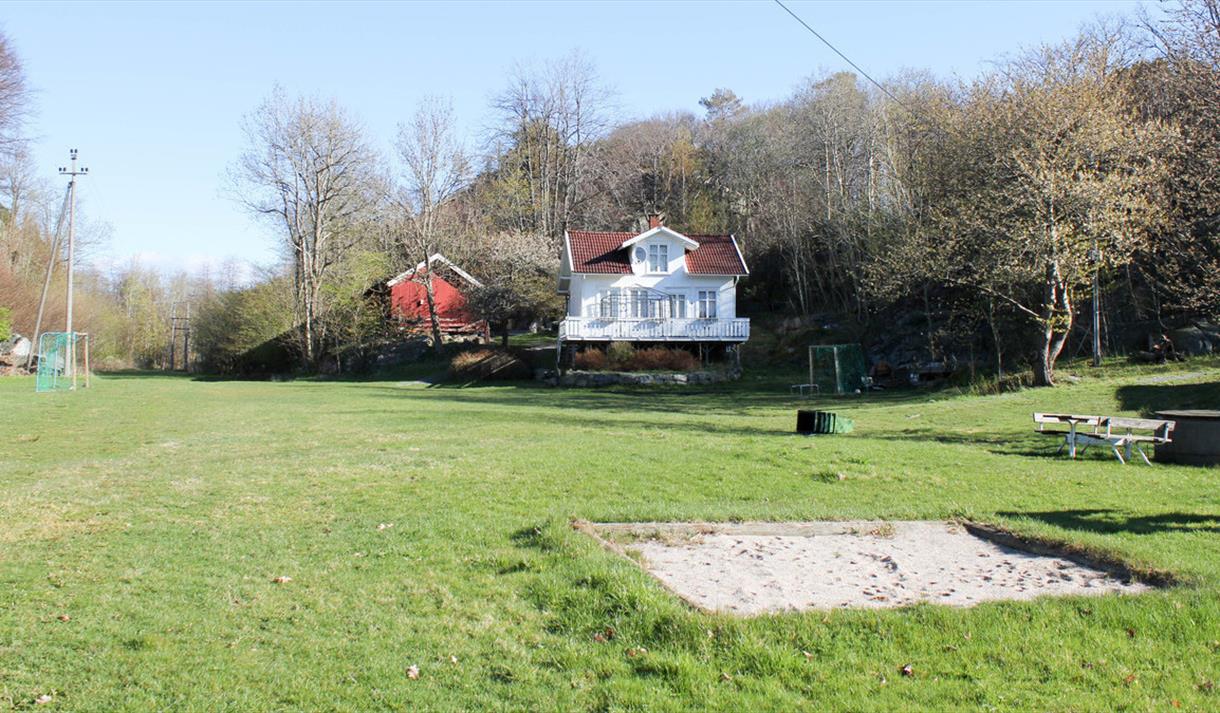 hus, gresslette og lekeplass på Stokkøya